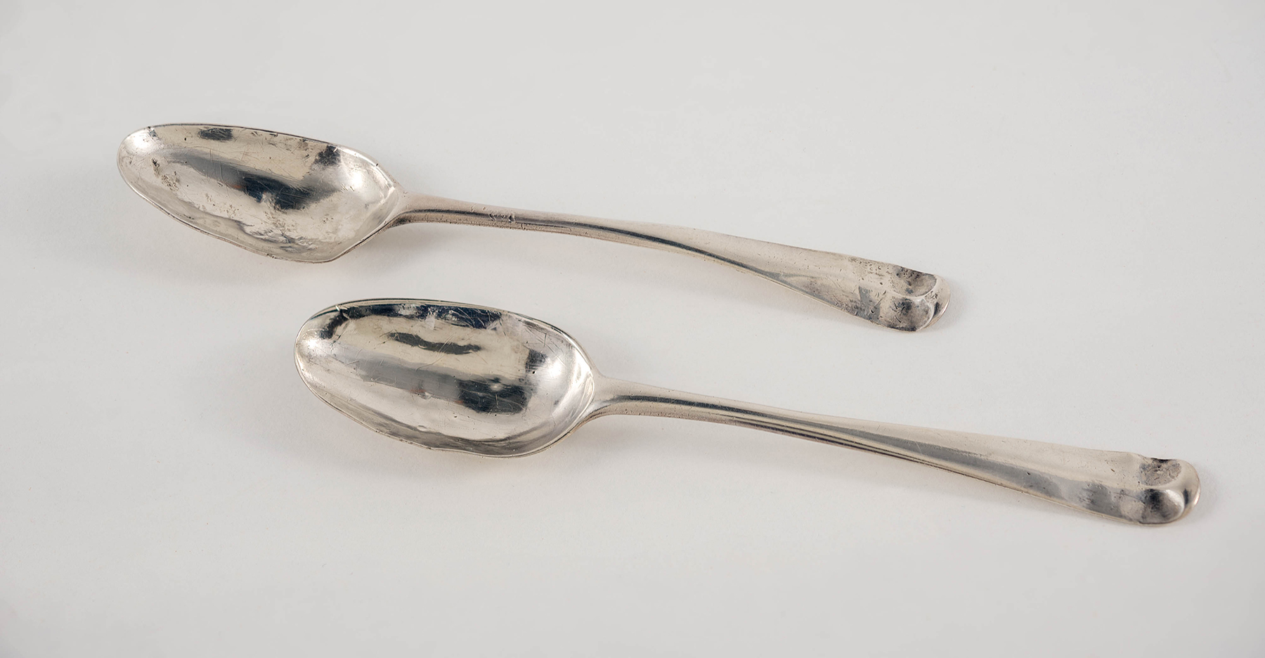 A close-up photograph of two silver teaspoons