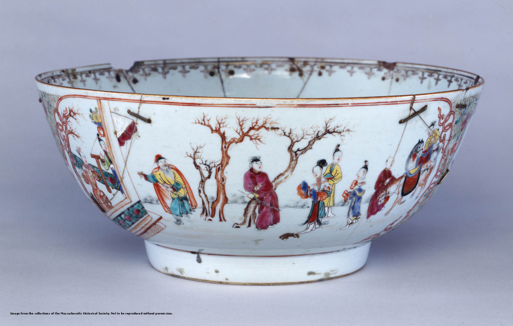 porcelain bowl showing scenes of Chinese people; the bowl is chipped and has visible staples in it to hold together crack