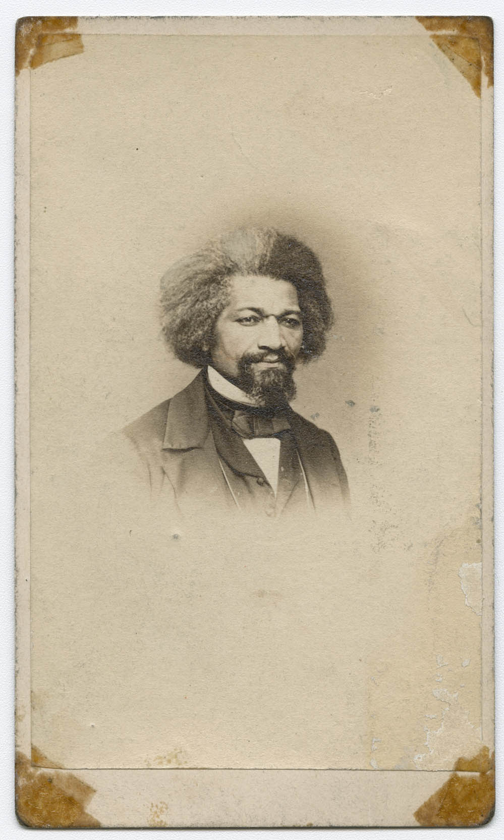 black-and-white photo of a Black man with an afro and goatee wearing a coat and bowtie in the center of a card