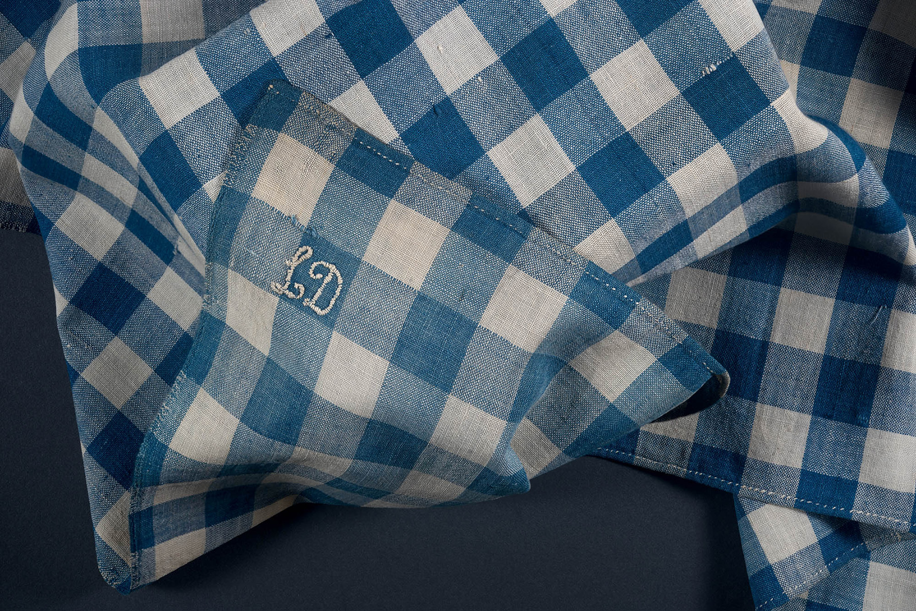Blue and white checkered fabric, with the initials 